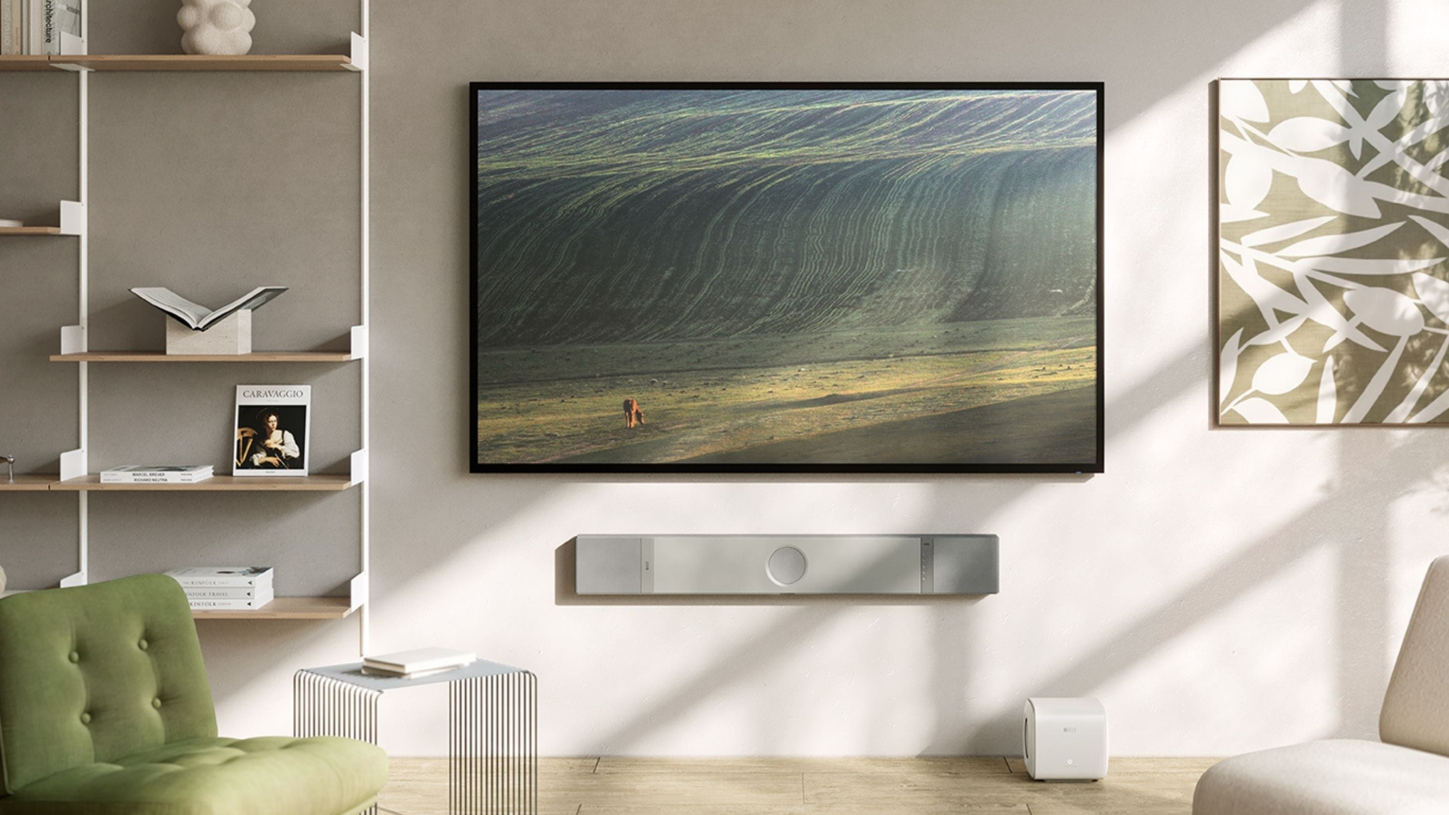 Modern living room with wall-mounted TV and sleek KEF soundbar, illustrating premium home cinema setup in natural light.