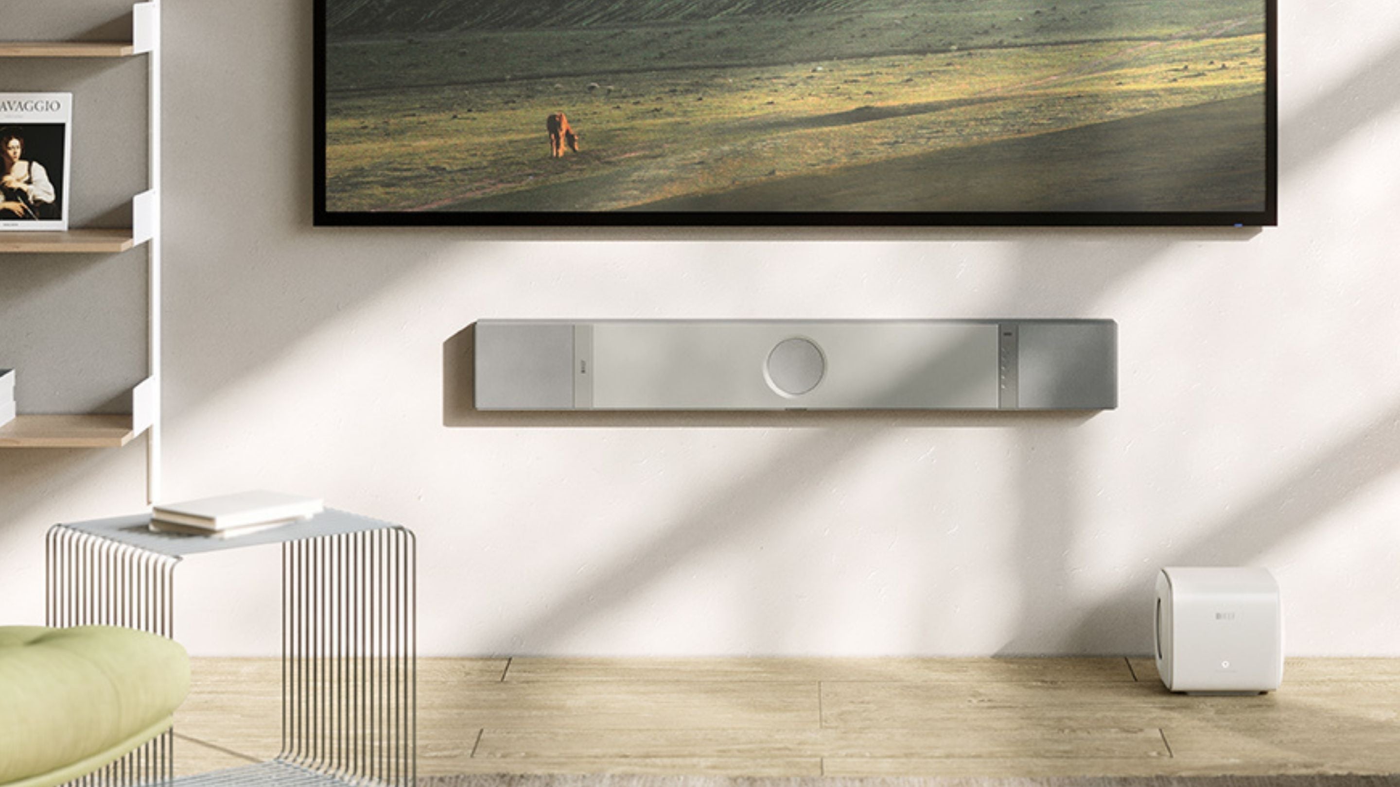 KEF XIO Soundbar mounted to a wall next to it is a KC62 Subwoofer