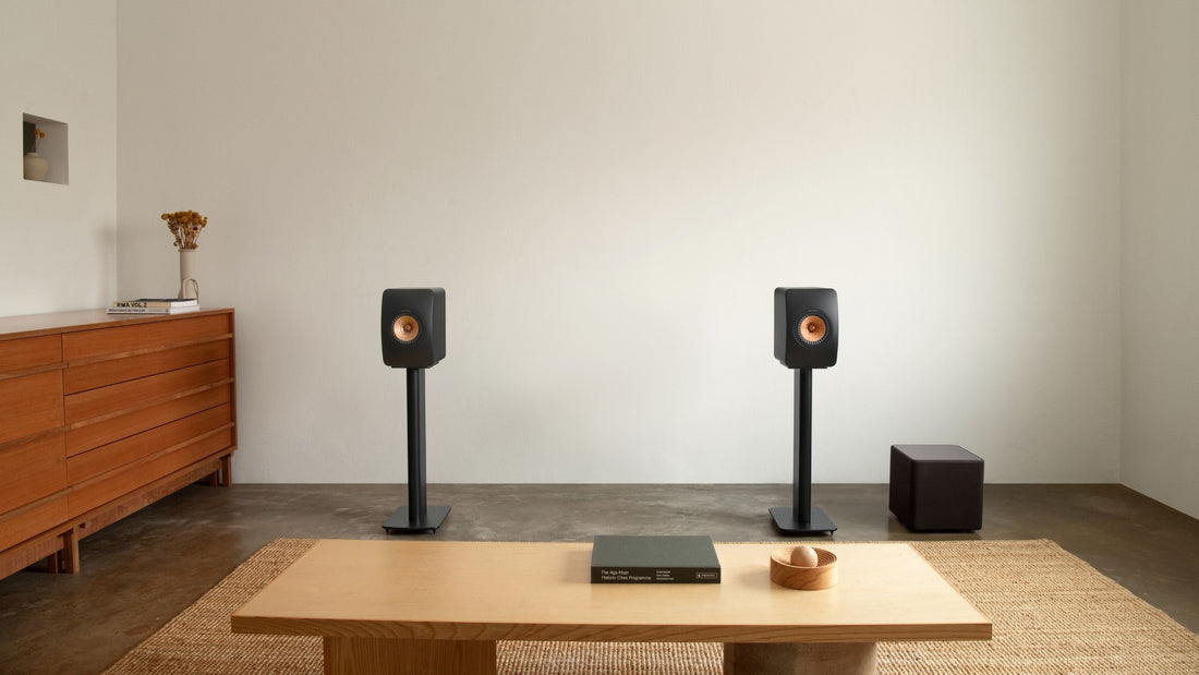 Home theater setup with LS50 Meta speakers and subwoofer in a room.