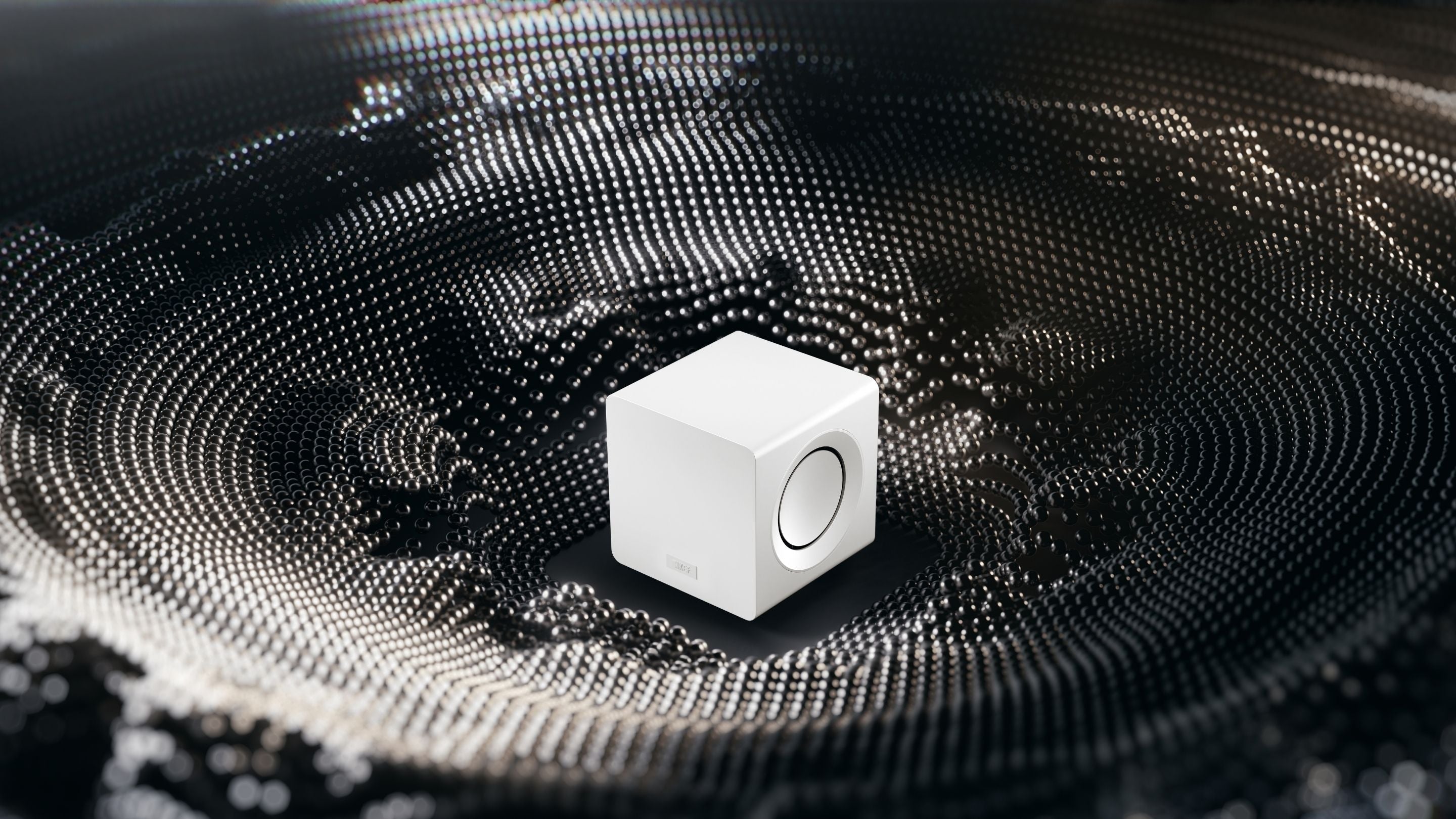 KEF KC92 subwoofer placed in the middle of dark grey absorption metarial