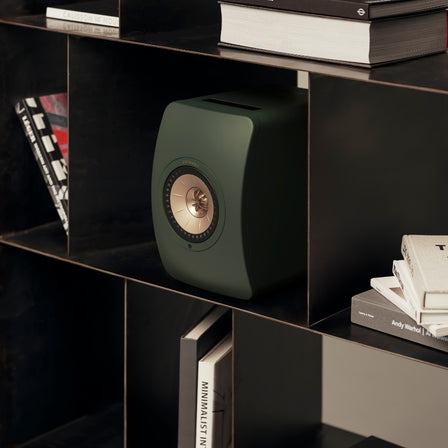 Green LS50 speaker in bookshelf.