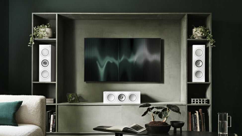 Three white R series speakers around TV bookshelf as left, centre and right channels.