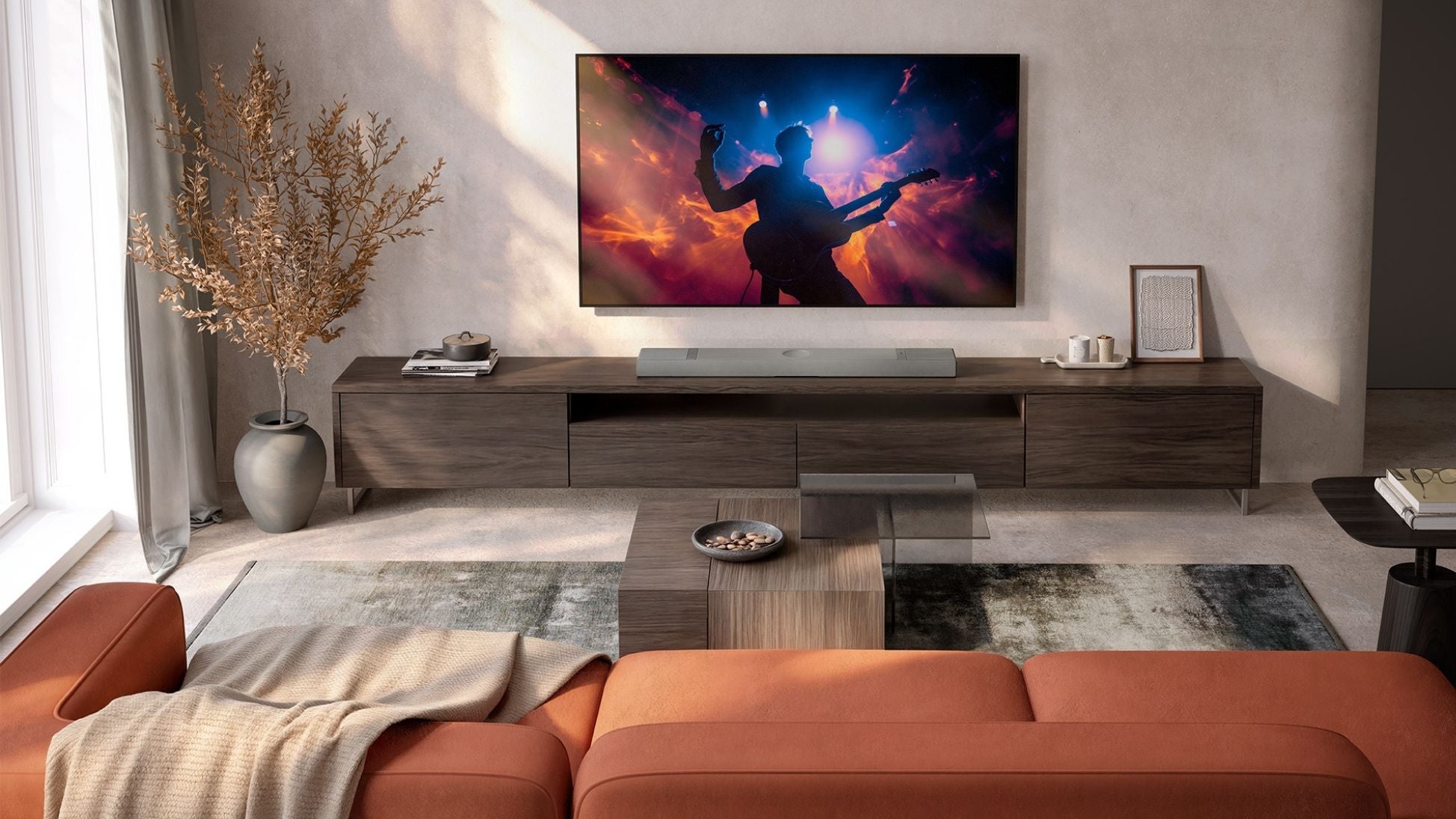 Modern living room with a television and XIO soundbar, surrounded by furniture and decor.